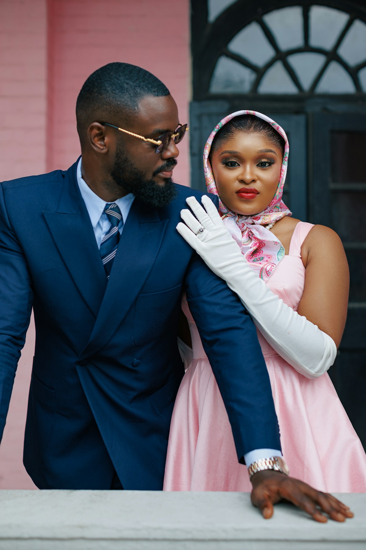 Male and female models in a tailored navy suit and pink dress